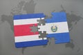 puzzle with the national flag of costa rica and el salvador on a world map background. Royalty Free Stock Photo