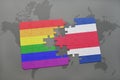 puzzle with the national flag of costa rica and gay rainbow flag on a world map background. Royalty Free Stock Photo