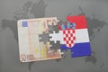 puzzle with the national flag of croatia and euro banknote on a world map background. Royalty Free Stock Photo