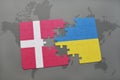 puzzle with the national flag of denmark and ukraine on a world map background. Royalty Free Stock Photo