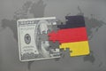 puzzle with the national flag of germany and dollar banknote on a world map background. Royalty Free Stock Photo