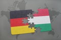 puzzle with the national flag of germany and hungary on a world map background.
