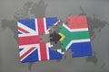 puzzle with the national flag of great britain and south africa on a world map background. Royalty Free Stock Photo