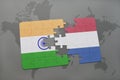 puzzle with the national flag of india and netherlands on a world map background. Royalty Free Stock Photo