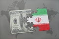 puzzle with the national flag of iran and dollar banknote on a world map background. Royalty Free Stock Photo