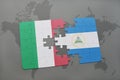 puzzle with the national flag of italy and nicaragua on a world map background.