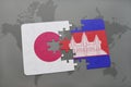 puzzle with the national flag of japan and cambodia on a world map background.