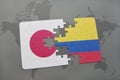 puzzle with the national flag of japan and colombia on a world map background.