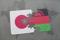 puzzle with the national flag of japan and malawi on a world map background.