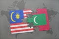 puzzle with the national flag of malaysia and maldives on a world map background.