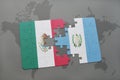 puzzle with the national flag of mexico and guatemala on a world map background. Royalty Free Stock Photo