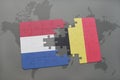 Puzzle with the national flag of netherlands and belgium on a world map background. Royalty Free Stock Photo
