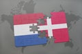 Puzzle with the national flag of netherlands and denmark on a world map background. Royalty Free Stock Photo