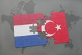 puzzle with the national flag of netherlands and turkey on a world map background. Royalty Free Stock Photo