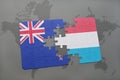 puzzle with the national flag of new zealand and luxembourg on a world map background