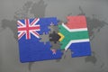 puzzle with the national flag of new zealand and south africa on a world map background. Royalty Free Stock Photo