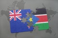 puzzle with the national flag of new zealand and south sudan on a world map background. Royalty Free Stock Photo