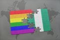 puzzle with the national flag of nigeria and gay rainbow flag on a world map background. Royalty Free Stock Photo