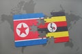 puzzle with the national flag of north korea and uganda on a world map