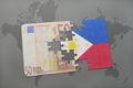 Puzzle with the national flag of philippines and euro banknote on a world map background.