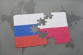 puzzle with the national flag of russia and poland on a world map background. Royalty Free Stock Photo