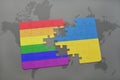 puzzle with the national flag of ukraine and gay rainbow flag on a world map background. Royalty Free Stock Photo