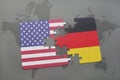 Puzzle with the national flag of united states of america and germany on a world map background Royalty Free Stock Photo