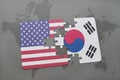 puzzle with the national flag of united states of america and south korea on a world map background Royalty Free Stock Photo