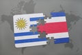 puzzle with the national flag of uruguay and costa rica on a world map background. Royalty Free Stock Photo