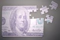 Puzzle with the one hundred dollars banknote on a gray background Royalty Free Stock Photo