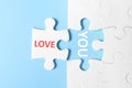 Puzzle with phrase LOVE YOU on blue background, top view