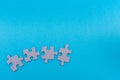 Puzzle pieces blank about to connect on bright blue flat lay background for team work, unity, completion concepts in business, Royalty Free Stock Photo