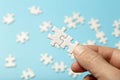 Puzzle pieces are connected. White puzzle pieces in hand on a blue background. Business, partner, solution, alliance Royalty Free Stock Photo