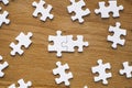 Puzzle pieces are connected. White puzzle pieces on a wooden table background. Business, partner, solution, alliance Royalty Free Stock Photo