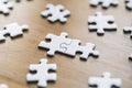 Puzzle pieces are connected. White puzzle pieces on a wooden table background. Business, partner, solution, alliance Royalty Free Stock Photo