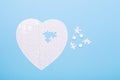 Puzzle in shape of heart and white pills on blue background Jigsaw Concept treatment of heart disease pills Royalty Free Stock Photo