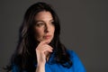 Puzzled adult woman looking up and around on grey background. Worried contemplative face expressions. Pretty european