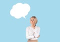 Puzzled business lady with speech bubble on blue studio background, mockup for design