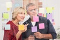 Puzzled business team looking post its on the wall Royalty Free Stock Photo