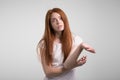 Puzzled and clueless young redhead woman with arms out