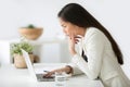 Puzzled confused asian woman thinking hard looking at laptop scr