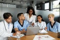 Puzzled doctors discussing medical cases, using laptop Royalty Free Stock Photo