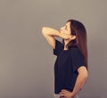 Puzzled doubt thinking young brunette woman looking serious up on empty copy space grey studio background in black casual t-shirt Royalty Free Stock Photo