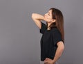 Puzzled doubt thinking young brunette woman looking serious up on empty copy space grey studio background in black casual t-shirt Royalty Free Stock Photo