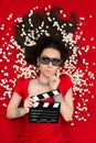 Puzzled Girl with 3D Cinema Glasses, Popcorn and Director Clapboard