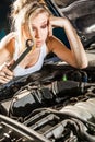 Puzzled girl trying to repair their own broken car