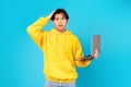 Puzzled Japanese Teen Guy Holding Laptop Touching Head, Blue Background