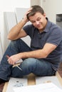 Puzzled Man Assembling Flat Pack Furniture