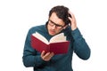 Puzzled man reading a book, scratching his head, isolated on white background. Student or professor wears eyeglasses looking Royalty Free Stock Photo