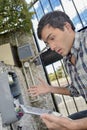 Puzzled man trying to repair electrical device